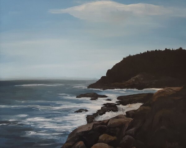A rocky shoreline with waves crashing against dark rocks under a blue sky. The coastline curves toward a tree-covered hill in the distance, and a white cloud floats above the horizon.
